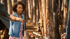 a woman holding a knife in the woods