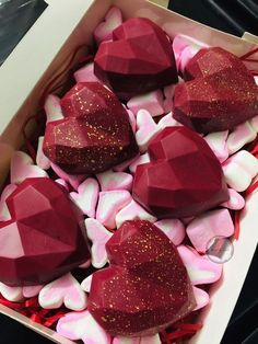 there are many heart shaped candies in the box