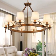 a chandelier in a living room with flowers on the table