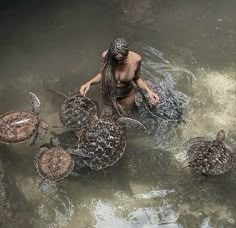 a man in the water surrounded by turtles