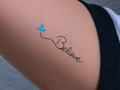 a woman's arm with a tattoo that says believe and a blue bird on it