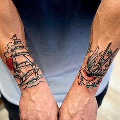 two hands with tattoos on them are holding each other's fingers and one has a ship in the middle