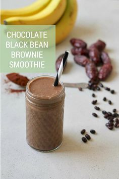 a smoothie in a mason jar next to bananas and raisins on a table