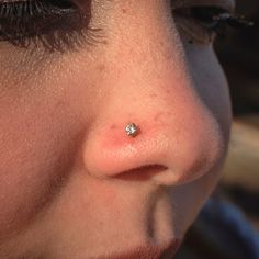 a woman's nose with a tiny piercing on it