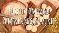 frosted homemade pumpkin sugar cookies on a cutting board next to a bowl of milk