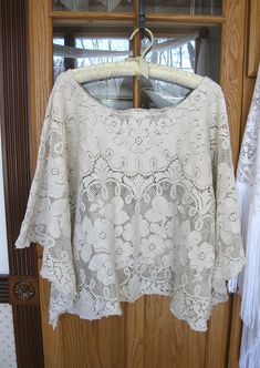 Beige vintage cotton lace is repurposed to create a one of a kind loose and flowey top to be worn over a camisole with jeans, capris, or long skirt. Fits up to a size L. The neck opening is 13 inches across. The bust measures 23 inches across lying flat. Machine wash gentle, tumble dry. As with all vintage materials, there may be a small snag or flaw. Browse more of my upcycled fashions at https://www.etsy.com/shop/LilyWhitepad?ref=hdr_shop_menu Summer Beige Tops With Lace Sleeves, Summer Lace Blouse In Cottagecore Style, Bohemian Blouse With Lace Sleeves, Spring Bohemian Scalloped Lace, Flowy Lace Bohemian Blouse, Bohemian Scalloped Lace For Summer, Bohemian Flowy Top With Lace Trim, Beige Lace Tops With Delicate Lace, Beige Lace Tops With Delicate Details