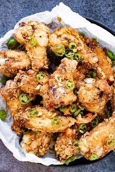 chicken wings with green peppers and onions in a bowl