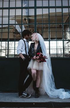 a man and woman standing next to each other in front of a building with bars