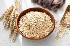 oatmeal in a bowl next to some ears of wheat on a table