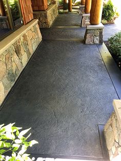 the walkway is lined with stone pillars and plants on either side of the entrance to the building