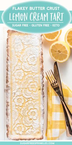 a lemon tart is sitting on a table next to some forks and oranges