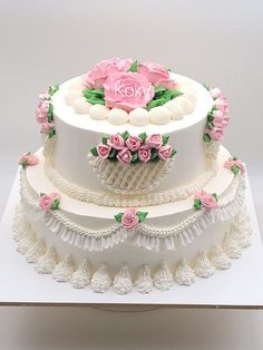 a three tiered cake with pink flowers and seashells