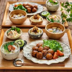 a wooden tray topped with bowls filled with food