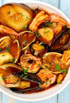 a white bowl filled with seafood and mussels