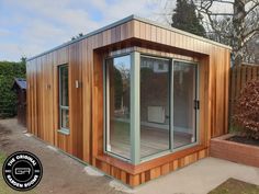 a small wooden building with glass doors and windows