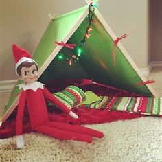 an elf laying on the floor next to a tent