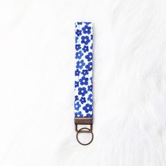 a blue and white flowered key fobring on a furry surface with a metal ring