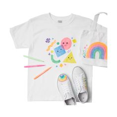 a t - shirt, pair of shoes and crayons on a white background