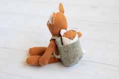 an orange and white stuffed animal sitting on top of a wooden floor next to a bag