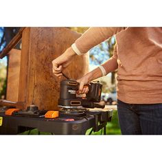 a person using a power tool on a piece of wood