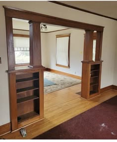 an empty living room with wood floors and bookcases