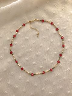 "This necklace features red poinsettias and holiday colors: cream, red, greens, and 24k gold plated seed beads. Length: 15\" inches Seed Bead Size: 11/0, 6/0 Adjustable: Each necklace has a 2.5\" gold filled lobster clasp extender Strung on: Non-Stretchy Beading Thread" Red Flower-shaped Beaded Necklaces For Gifts, Red Flower-shaped Beaded Necklace For Gift, Adjustable Red Flower Beaded Necklace, Adjustable Red Flower Beaded Necklaces, Dainty Red Flower Necklace, Gold Beaded Necklace For Christmas, Holiday Gold Beaded Necklace, Christmas Gold Beaded Necklace, Red Bead Necklace