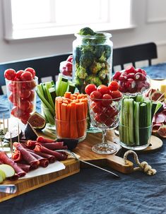 a table topped with lots of different types of vegetables and meats on top of wooden cutting boards