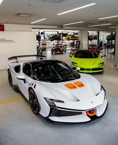 two white sports cars parked in a showroom