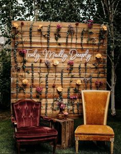 two chairs and a wooden wall with flowers on it