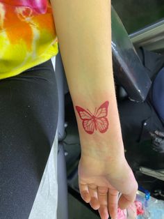 a woman's arm with a butterfly tattoo on the left side of her wrist