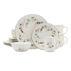 a set of white dishes and cups with red flowers on the rims are shown