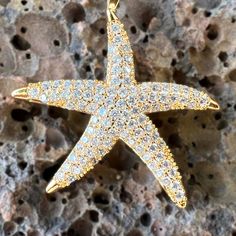 Get noticed with this sparkling 18K Gold Filled Large Star Fish Pendant. Each cubic zirconia is individually mounted to create an organic textured look with incredible shine. Each tip of the Star Fish has a polished finish further accenting the design. Includes 18K Gold Filled 3mm width, extra long 24 inch length Chain. 18K Gold Filled Star Fish Pendant Cubic Zirconia individually mounted Incredible shine and sparkle Polished tips accent the design Includes 18K Gold Filled 3mm width, extra long Star-shaped Yellow Gold Cubic Zirconia Jewelry, Yellow Gold Star-shaped Cubic Zirconia Jewelry, Luxury Starfish-shaped Jewelry Gift, Gold Star-shaped Jewelry With Sparkling Stones, Gold Star Jewelry With Sparkling Stones, Star-shaped Cubic Zirconia Jewelry With Sparkling Stones, Cubic Zirconia Star Jewelry With Sparkling Stones, Star Shaped Cubic Zirconia Jewelry With Sparkling Stones, Fashionable Saree