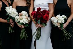 bridesmaids in black dresses holding bouquets of red and white flowers