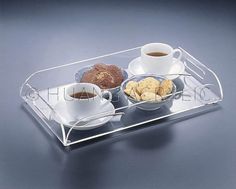 a tray with two cups of coffee, cookies and crackers on it is shown