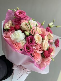 a bouquet of pink and white flowers in someone's hand