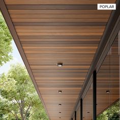 an outdoor covered walkway leading to the front door of a house with wood paneling