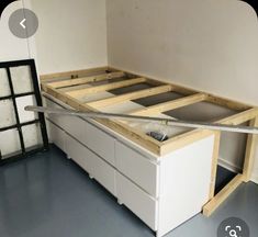 an unfinished bed frame with drawers in the middle