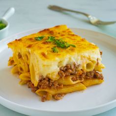 a white plate topped with lasagna and cheese