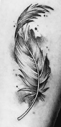 a black and white photo of a feather tattoo