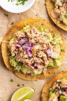 three tortillas topped with meat, onions and avocado