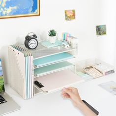 a laptop computer sitting on top of a desk next to a stack of binders