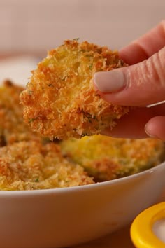 a person dipping some food into a bowl