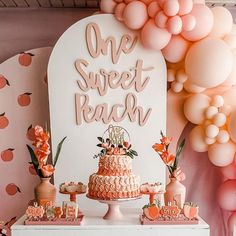 there is a cake on the table with balloons in the background and decorations around it