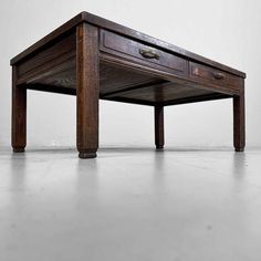 an old wooden table with two drawers on it's legs and one drawer open