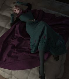 a woman laying on top of a bed under a purple blanket