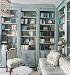 a living room filled with lots of furniture and bookshelves covered in blue bookcases