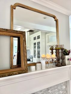 a fireplace with a mirror and candles on it