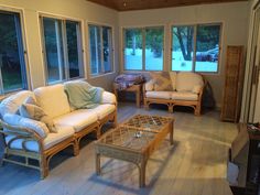 a living room filled with furniture and windows covered in wood planks on top of hard wood flooring