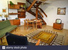 a living room filled with furniture and a spiral stair case next to a wooden table