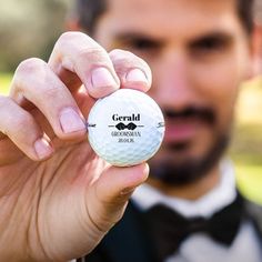 a man in a tuxedo holding a golf ball with the name gerald on it